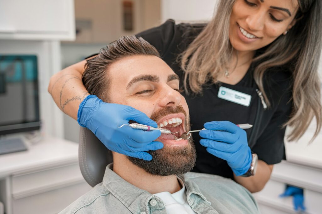 Dentist examining a smiling patient to check a tooth